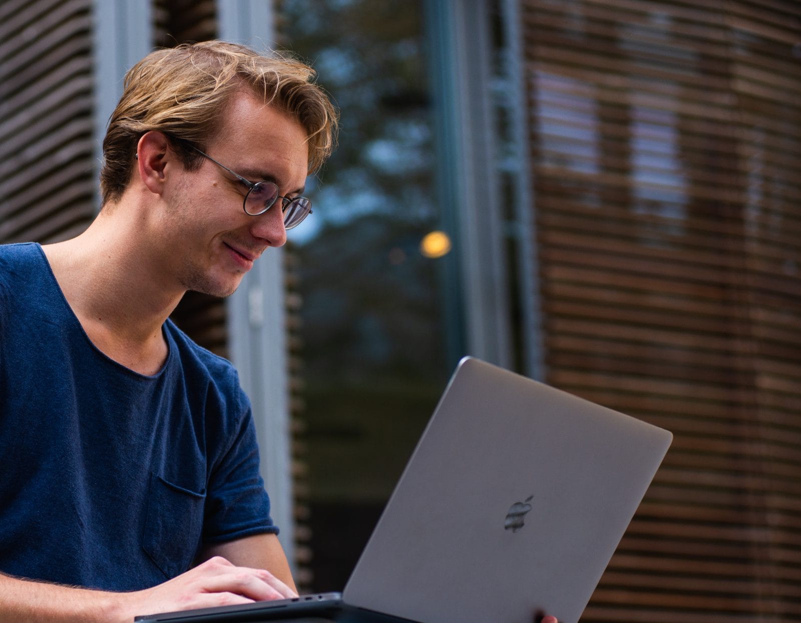 Jeune étudiant avec un ordinateur portable sur les genoux